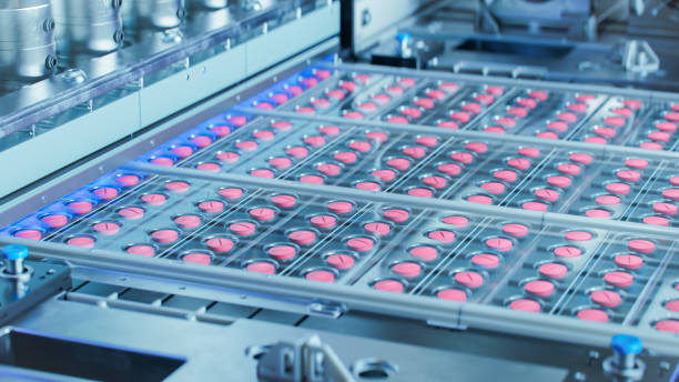 現代の製薬工場での生産および梱包プロセス中のピンクの錠剤。医薬品製造。
