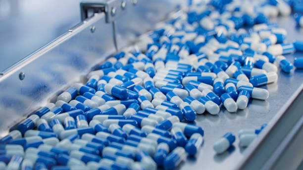istock Blue Capsules are Moving on Conveyor at Modern Pharmaceutical Factory. Tablet and Capsule Manufacturing Process. Close-up Shot of Medical Drug Production Line. 1465073103