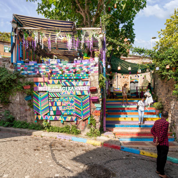 tourists at traditional cafe decorated with multicolored panels and colorful stairs, balat district, istanbul, turkey - balat stok fotoğraflar ve resimler