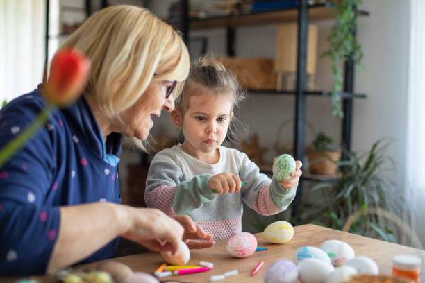 istock Girl painting eggs for easter with grandma 1465085184
