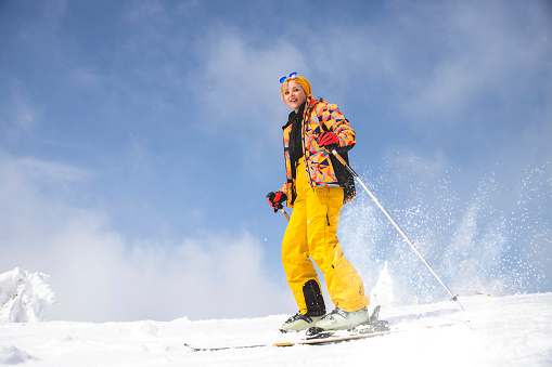 Active Woman skiing on snowy mountain ski slope. Full length. Copy space