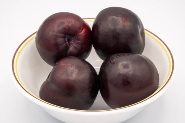 istock Plums in a bowl on a white background 1465096319