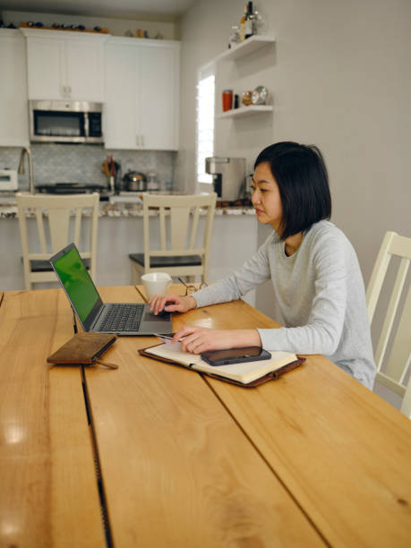 istock Woman in a Home Usuing a Laptop Computer and Smartphone 1465098398