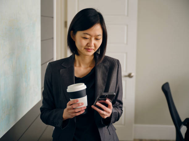 istock Woman in an Office Usuing a Laptop Computer and Smartphone 1465098882