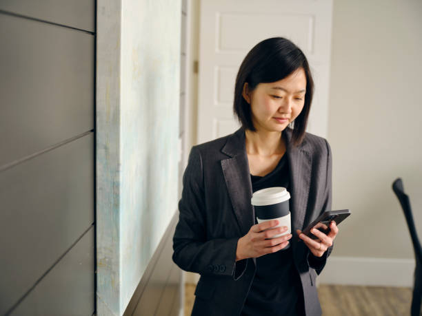 istock Woman in an Office Usuing a Laptop Computer and Smartphone 1465099420