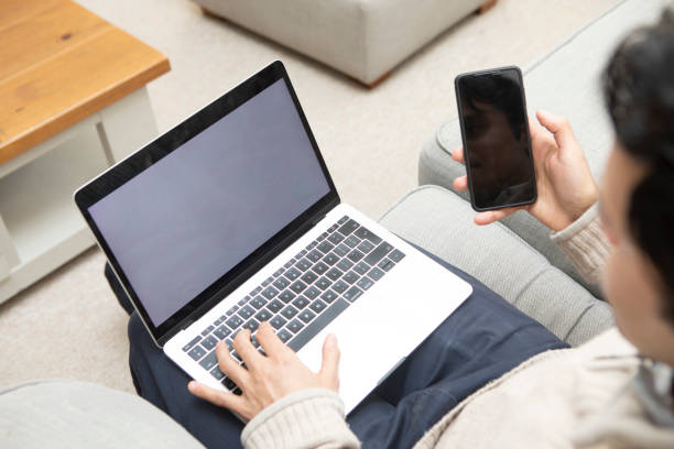 Over the shoulder view of a person working at home in a living room