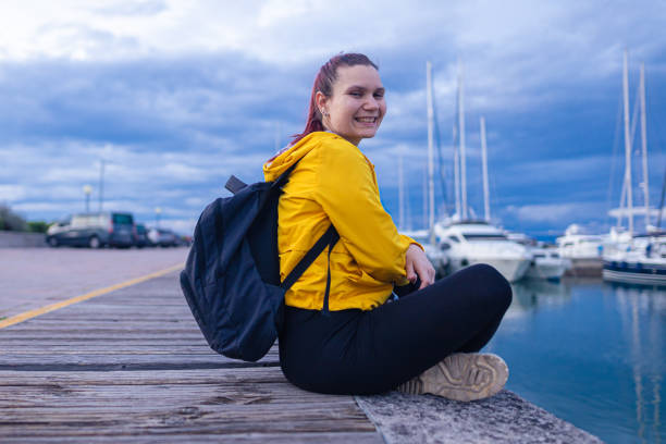 istock Young woman sitting on marina 1465101265