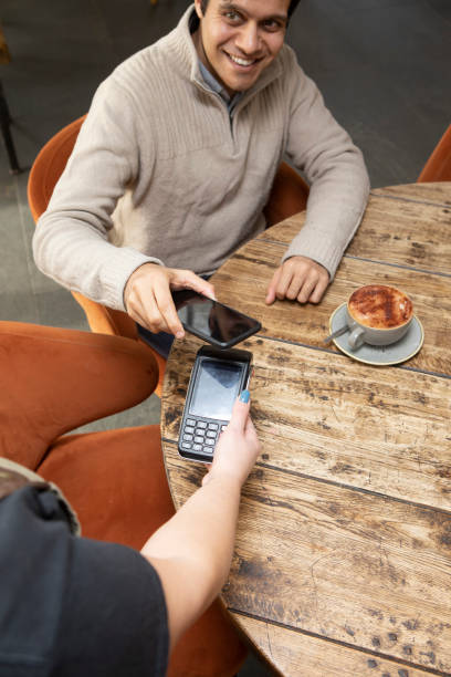 istock A professional man paying for a coffee by mobile phone in a cafe 1465102685