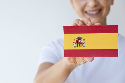 Hand is showing Spanish flag to camera.