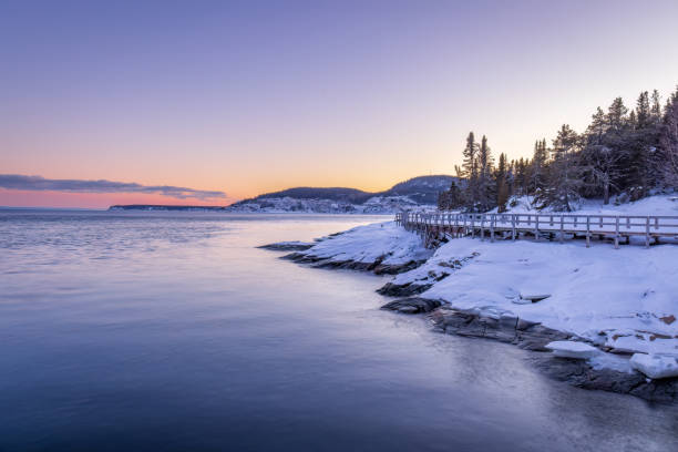 in tadoussac the footbridge of the pointe de l'islet allows you to see whales. during a sunset in winter. - saguenay imagens e fotografias de stock