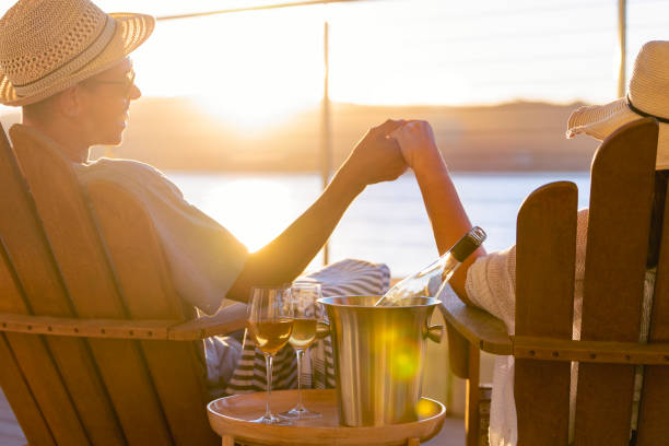istock Couple relaxing and drinking wine and holding hands on deck chairs 1465105496