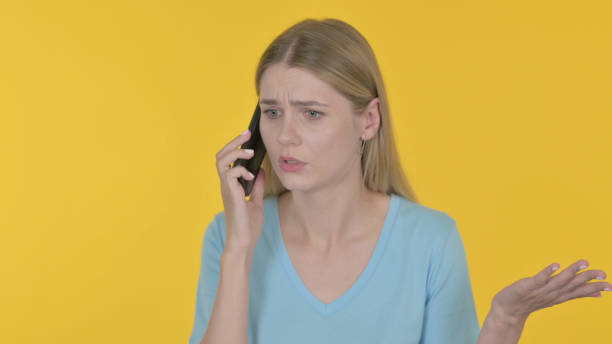 istock Young Woman Talking Angry on Phone on Yellow Background 1465110190