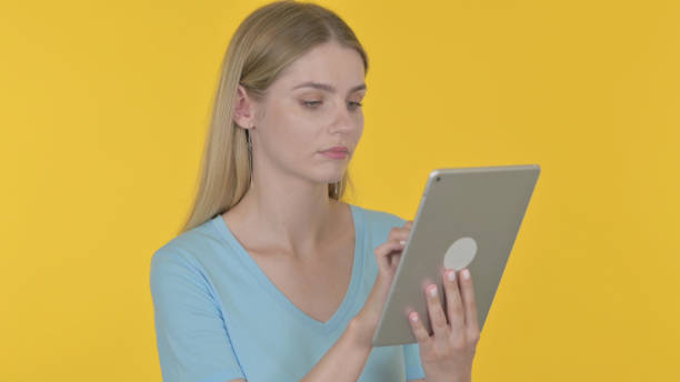 junge frau mit digitalem tablet auf gelbem hintergrund - 11270 stock-fotos und bilder