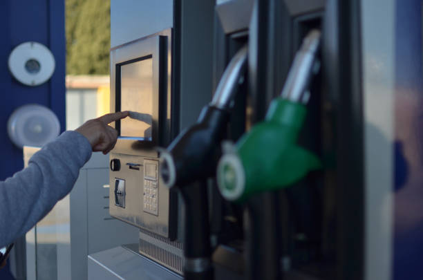 ein mann bezahlt die rechnung an einer tankstelle - gas counter stock-fotos und bilder