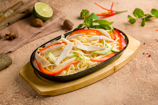 istock Udon noodles with chicken and vegetables on brown table 1465124114