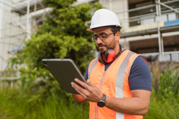 istock Project manager with safety vest and helmet using tablet. 1465127371