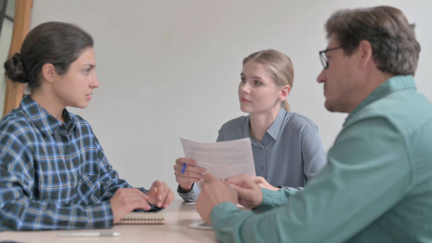 istock Young People Talking in Meeting, Paperwork 1465128761