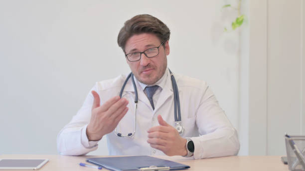 istock Blogging Doctor Talking in Camera in Clinic, Video Chat 1465131541