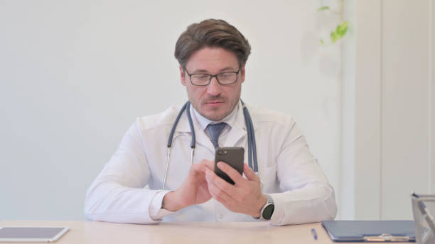 istock Middle Aged Doctor Using Smartphone in Clinic 1465131554