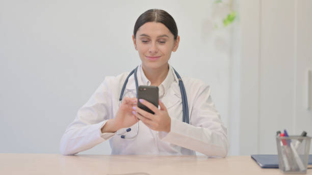 istock Young Female Doctor Using Smartphone in Clinic 1465132715