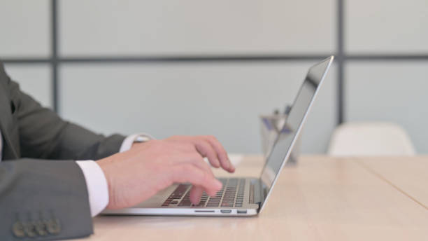 istock Side View of Businessman Typing on Laptop 1465133309