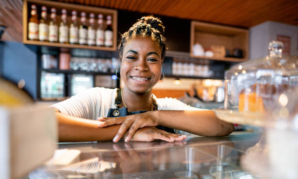 istock Barista smiling while standing behind the counter of a cafe 1465134483