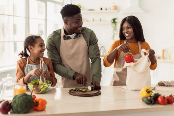 istock Cheerful Black Family Cooking Making Vegetable Salad In Modern Kitchen 1465137247