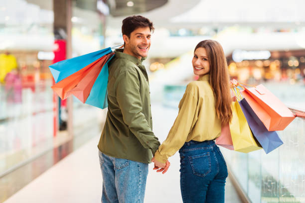 istock Happy Spouses Shopping Walking In Modern Mall, Posing Holding Hands 1465137970