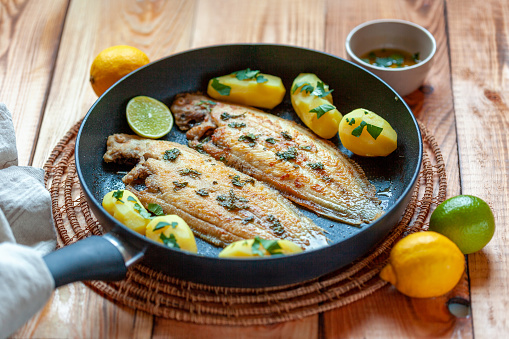 sole flatfish cooked on a pan, meuniere style, with butter and parsley, french cuisine, portion for two persons