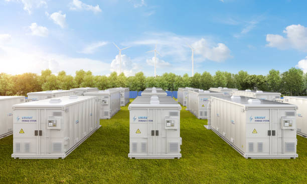 Amount of energy storage systems or battery container units with solar and turbine farm stock photo
