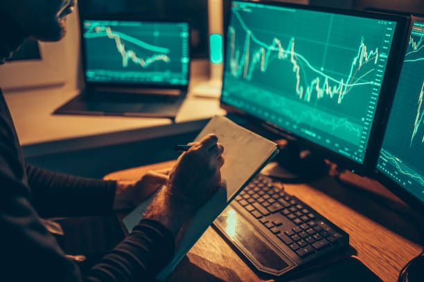 istock Nighttime Financial Planning of a man carefully analyzing a chart on his computer screen. 1465145742