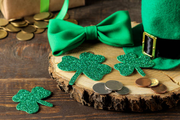 istock St.Patrick 's Day. celebration. Green leprechaun hat, money, bow tie and clover leaf on a brown background. 1465145831