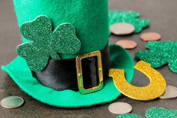 istock St.Patrick 's Day. celebration. A green leprechaun hat, money and a clover leaf and a horseshoe on a brown background. 1465145842