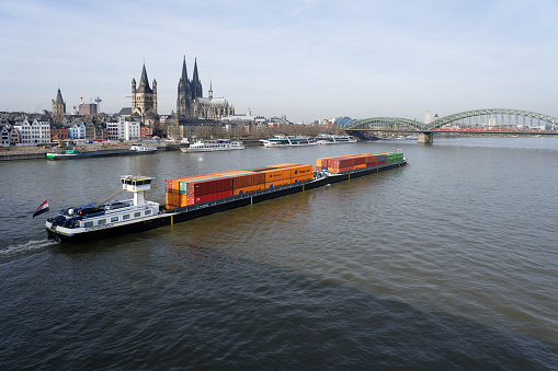 Cologne, Germany, February 09 2023 : a long container ship with a push barge passes through cologne on the rhine river