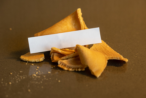Blank Fortune Sits On Broken Fortune Cookie on glass table