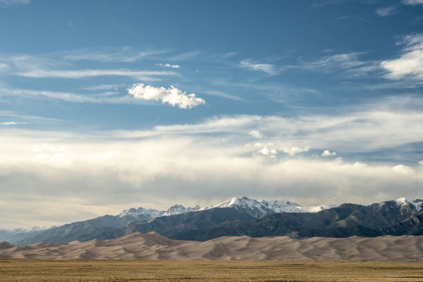 istock Blue Sky Emerges Over Great Sand Dunes and Snowy Mountains 1465154466