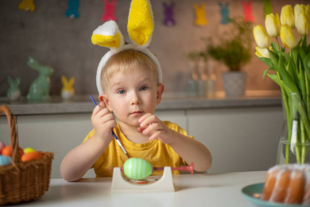 istock A little boy wearing bunny ears prepares painted Easter eggs for Easter while sitting at the kitchen table. Happy easter 1465157203