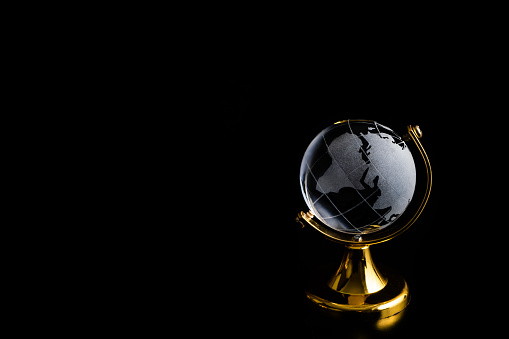 Miniature symbolic crystal globe on a black background