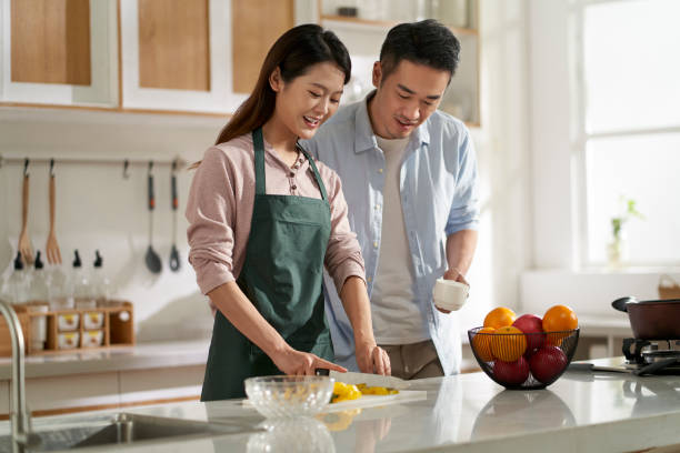 istock young asian couple talking chatting in kitchen 1465171005