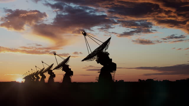 Radio telescopes pointing up in the sky during sunset in remote location