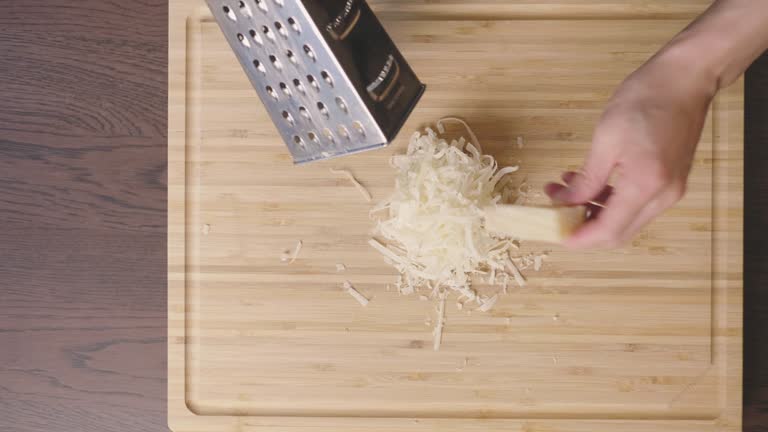 grating parmesan cheese on wooden chopping board