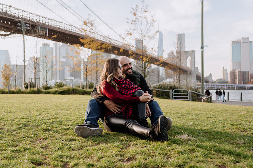 Latin couple sitting on the grass in a park in New York City
