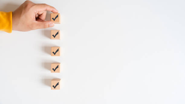 istock Checklist concept, wooden cubes with check marks on white table. Checklist, form filled in business. 1465188382