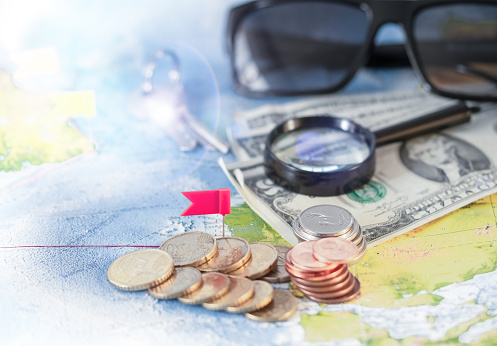 View of magnifier, eyeglasses, money, Travel and Holiday on world map background vintage tone. Concept of travel.