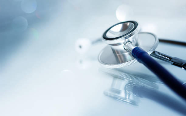 istock Stethoscope on glass table with reflection and copy space, monotone, soft background. Medical background 1465192026