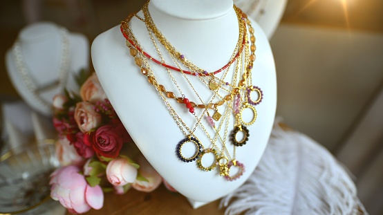 Stylish necklace with gemstones on jewelry bust.
