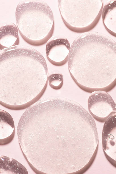istock Cosmetic lotion transparent gel drops texture background, pink 1465197382