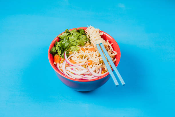 istock Instant noodles ramen soup on bowl and chopsticks on blue background 1465198556