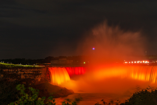 Niagara Falls lit up in red and gold. Ontario, Canada.