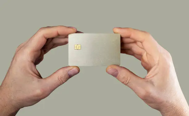 Bank card mockup, sample in men hands closeup. Blank debit credit bankcard with chip of gold color. High quality photo